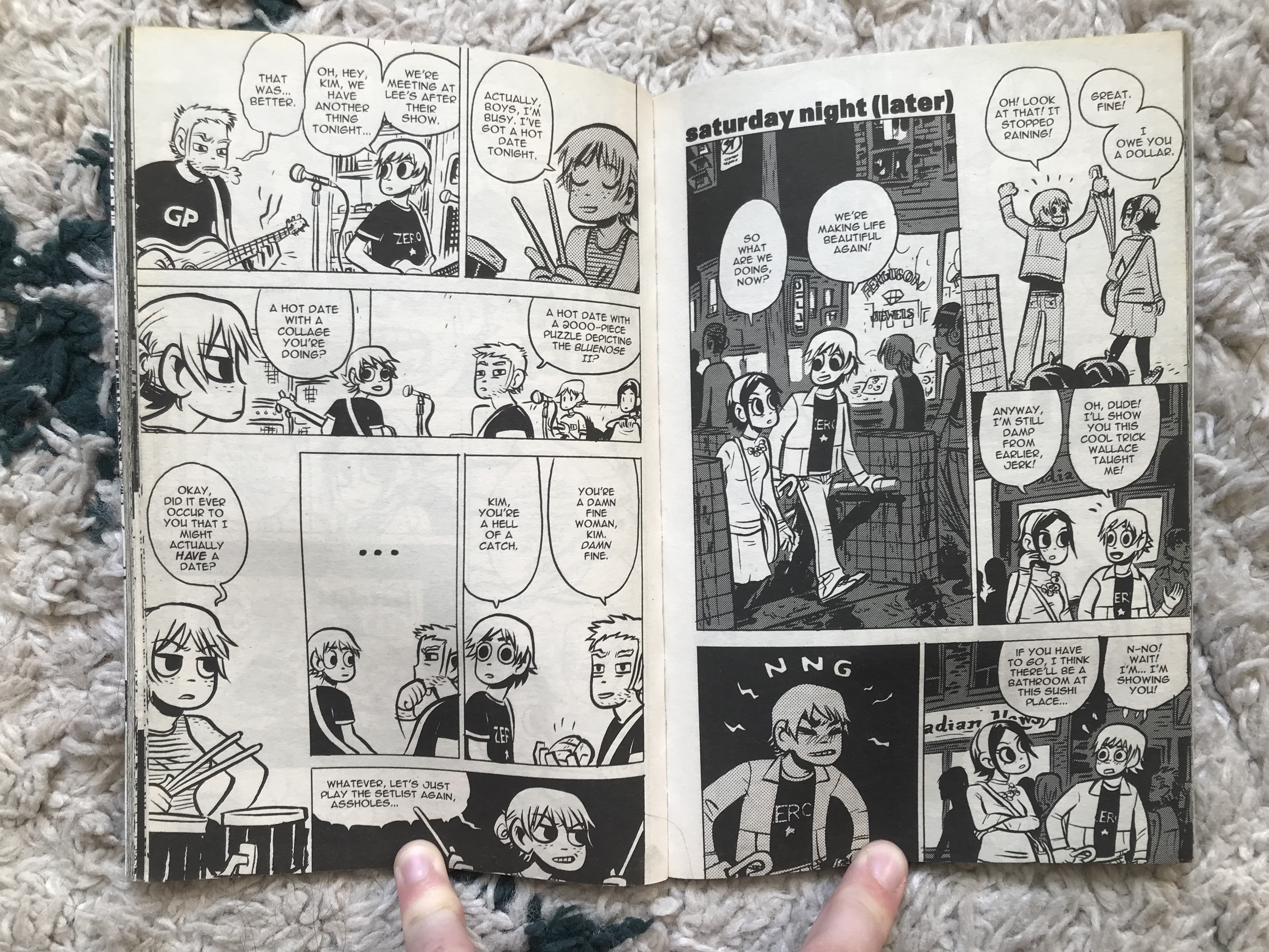 A photo of two black and white pages from the Scott Pilgrim comic books, showing a packed comic layout