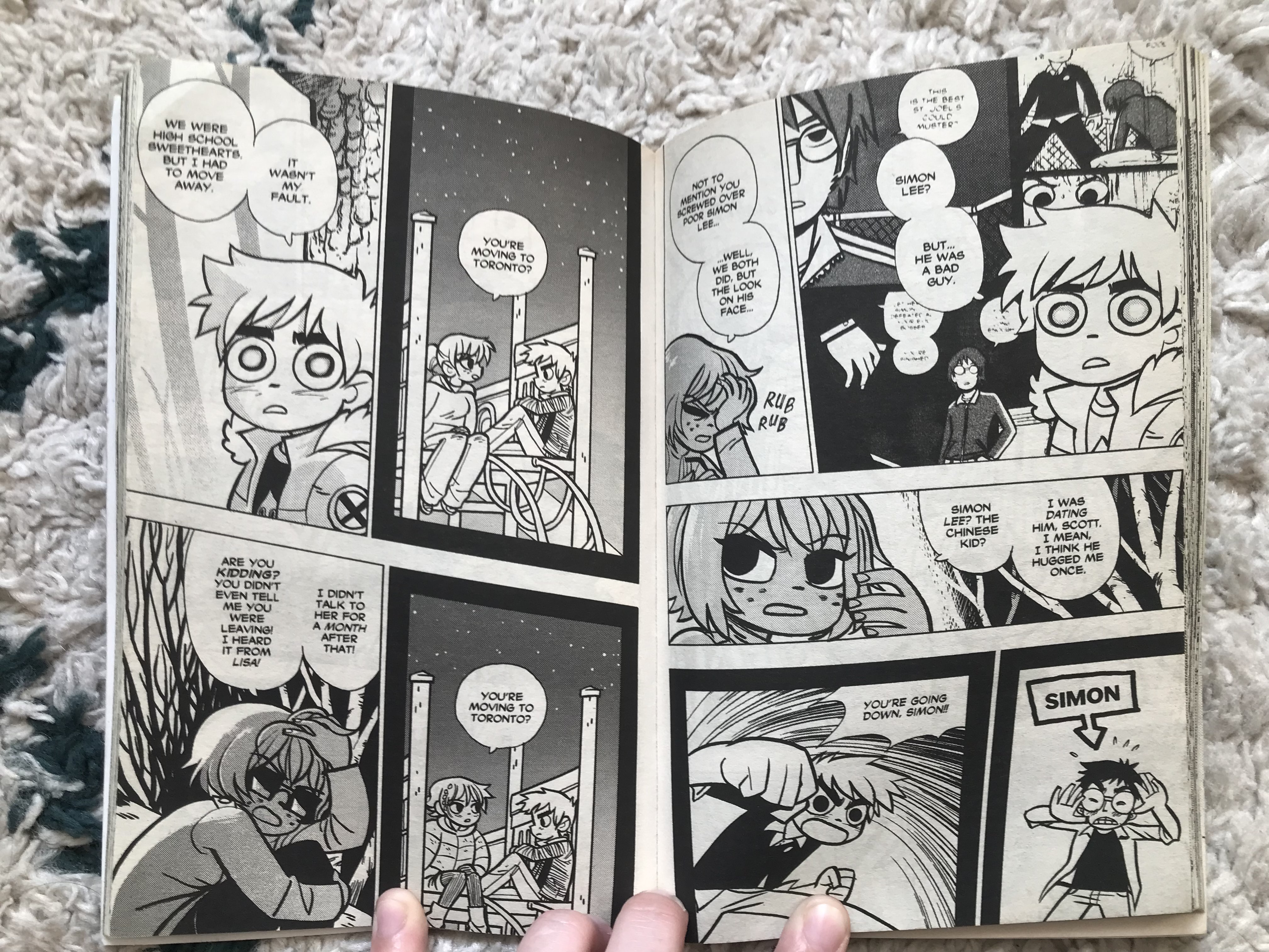 A photo of two black and white pages of Scott Pilgrim, showing Kim explaining to Scott how Scott hurt more in their previous relationship than he remembers, and how Scott imagined himself in a cool boss battle for Kim's affection when he actually beat up a classmate for no reason.