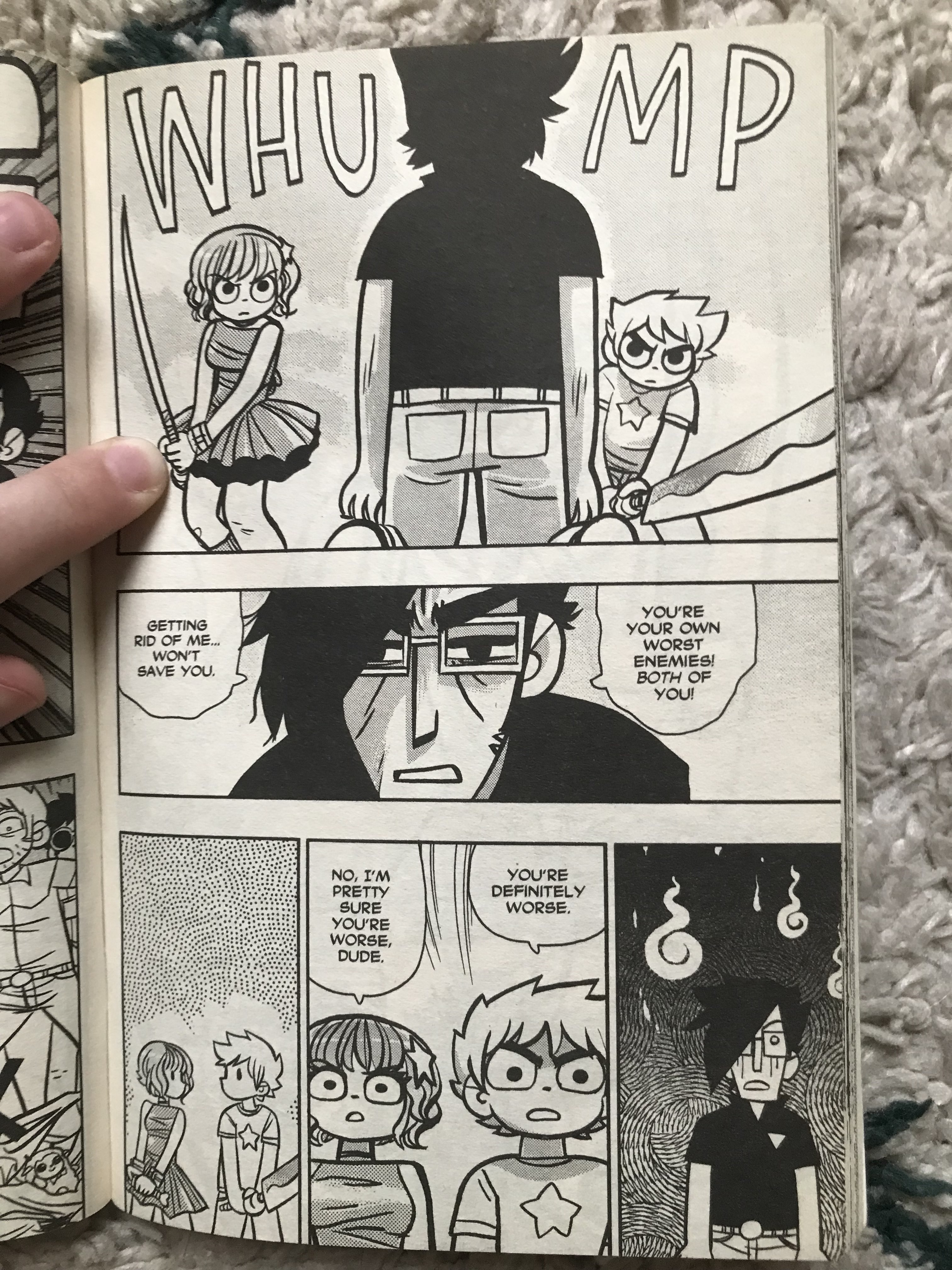 A photo of a single black and white page from Scott Pilgrim, showing Scott and Ramona facing down Gideon with swords. Gideon says that Scott and Ramona are each others' worst enemies, but Scott and Ramona agree he's definitely worse. 
