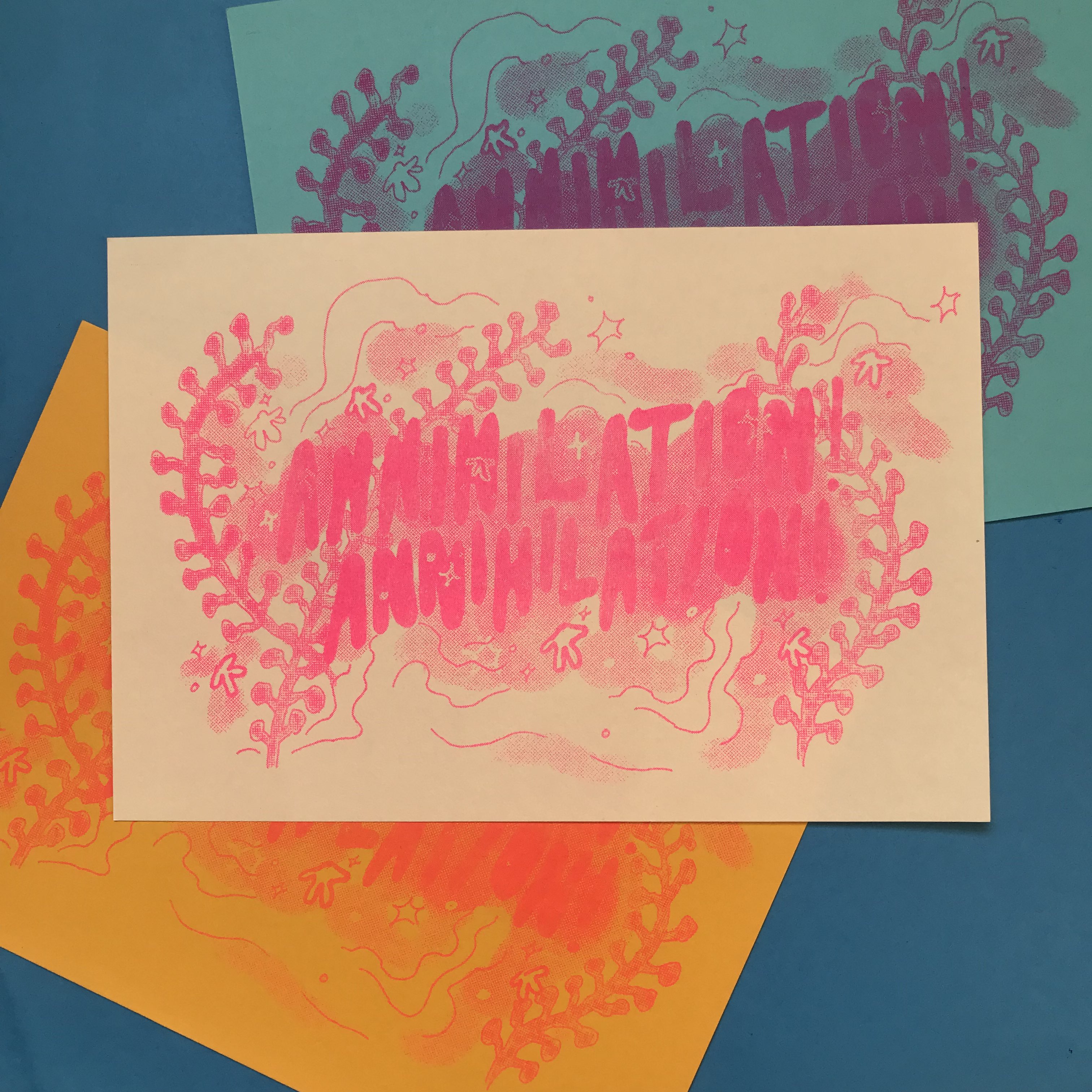 A product photo of a scattered pile of risoprints, all in pink ink, on blue and yellow paper with white at the top. The risoprint design has the text 'Annihilation! Annihilation!' in front of a halftone background with plants and spores.